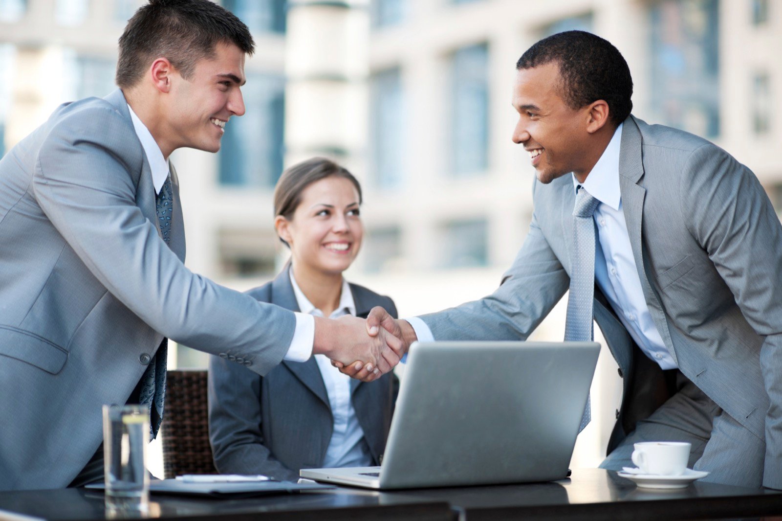 Two business people shaking hands over a benefits consultation.